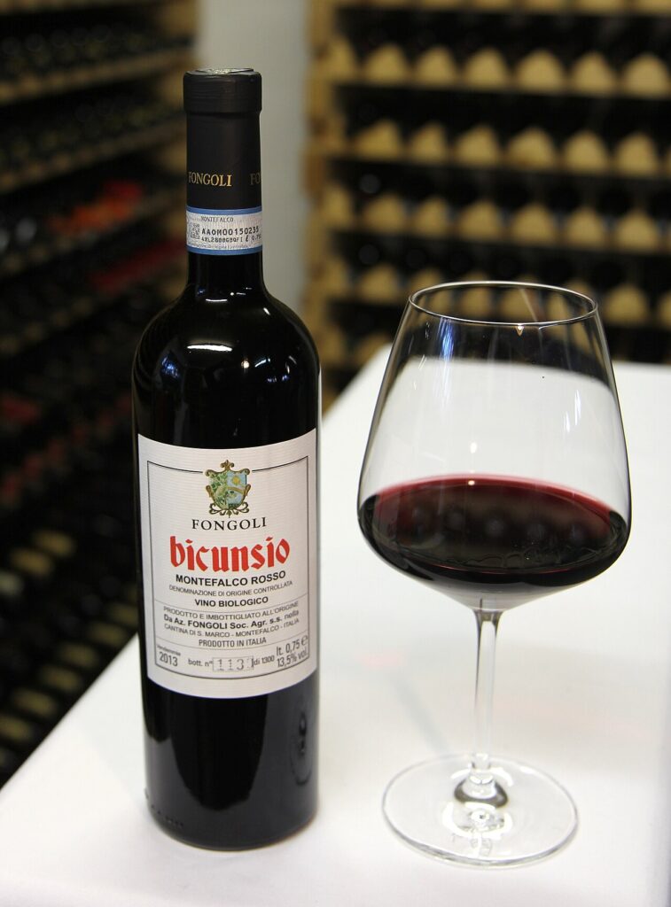 DOC, DOCG e IGT: guida alle denominazioni dei vini italiani 1 Bottiglia di vino rosso italiano con etichetta a Denominazione di Origine Controllata (DOC) accanto a un calice